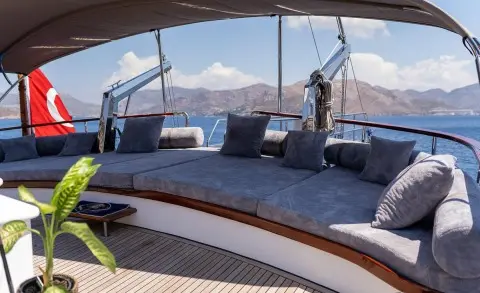 Wide outdoor deck with gray cushions and a sea view on a luxurious yacht