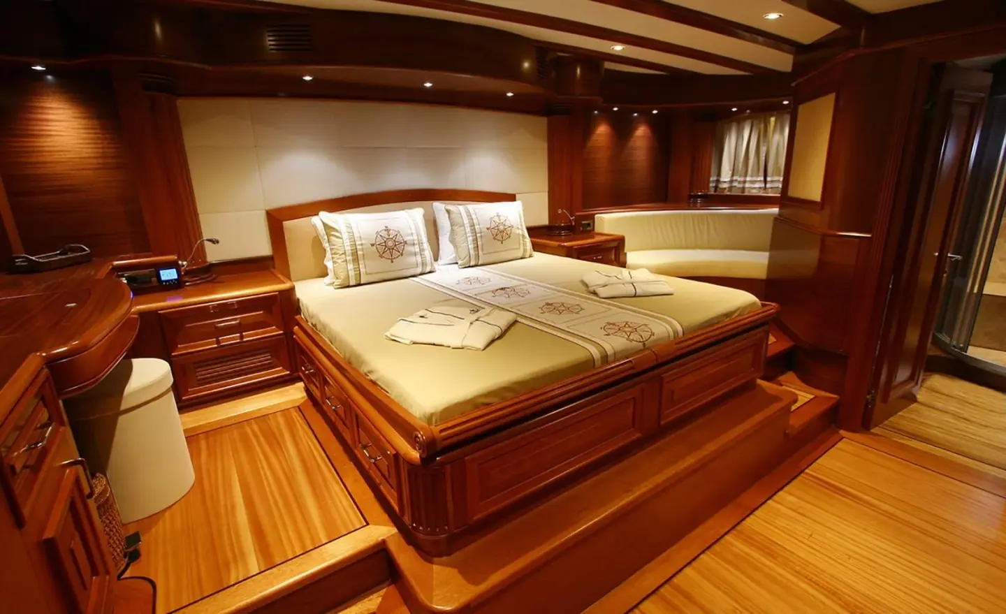 Interior of Kaya Guneri 5 master cabin with large bed and wooden tones