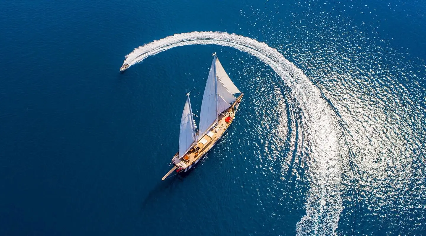 Grande Mare yacht sailing at sunset with a small wake and blue sea