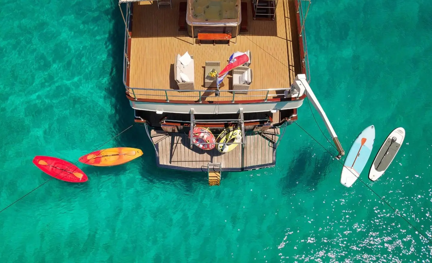 Bird's-eye view of Luna yacht anchored in turquoise water with people on deck