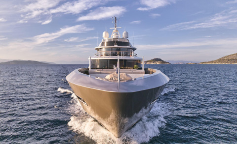 Front view of the luxury motor yacht cutting through the sea with its wide hull and open stern scenery