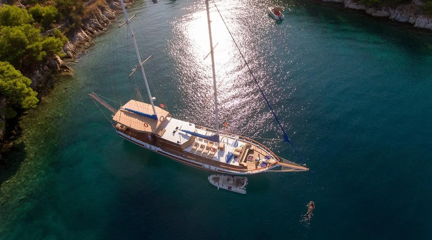 A luxury gulet named Malena gliding on calm turquoise sea at sunset