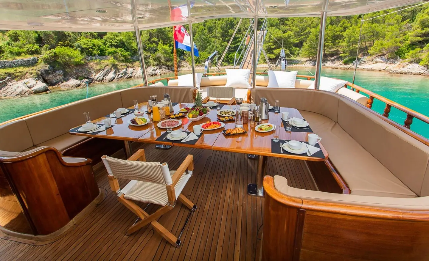 Dolce Vita yacht dining area on deck with table set at sunset