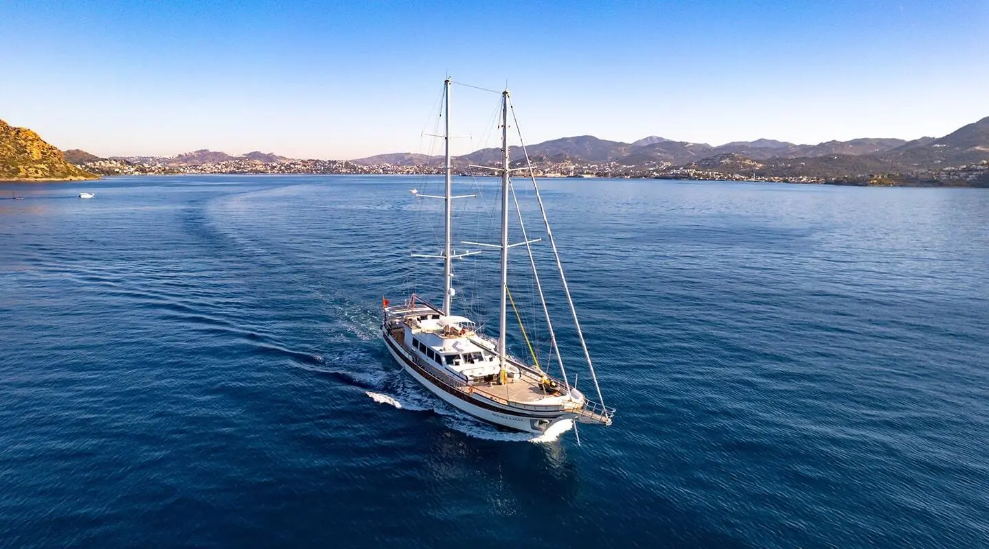 Double Eagle luxury gulet anchored on calm blue sea at sunset with sails down