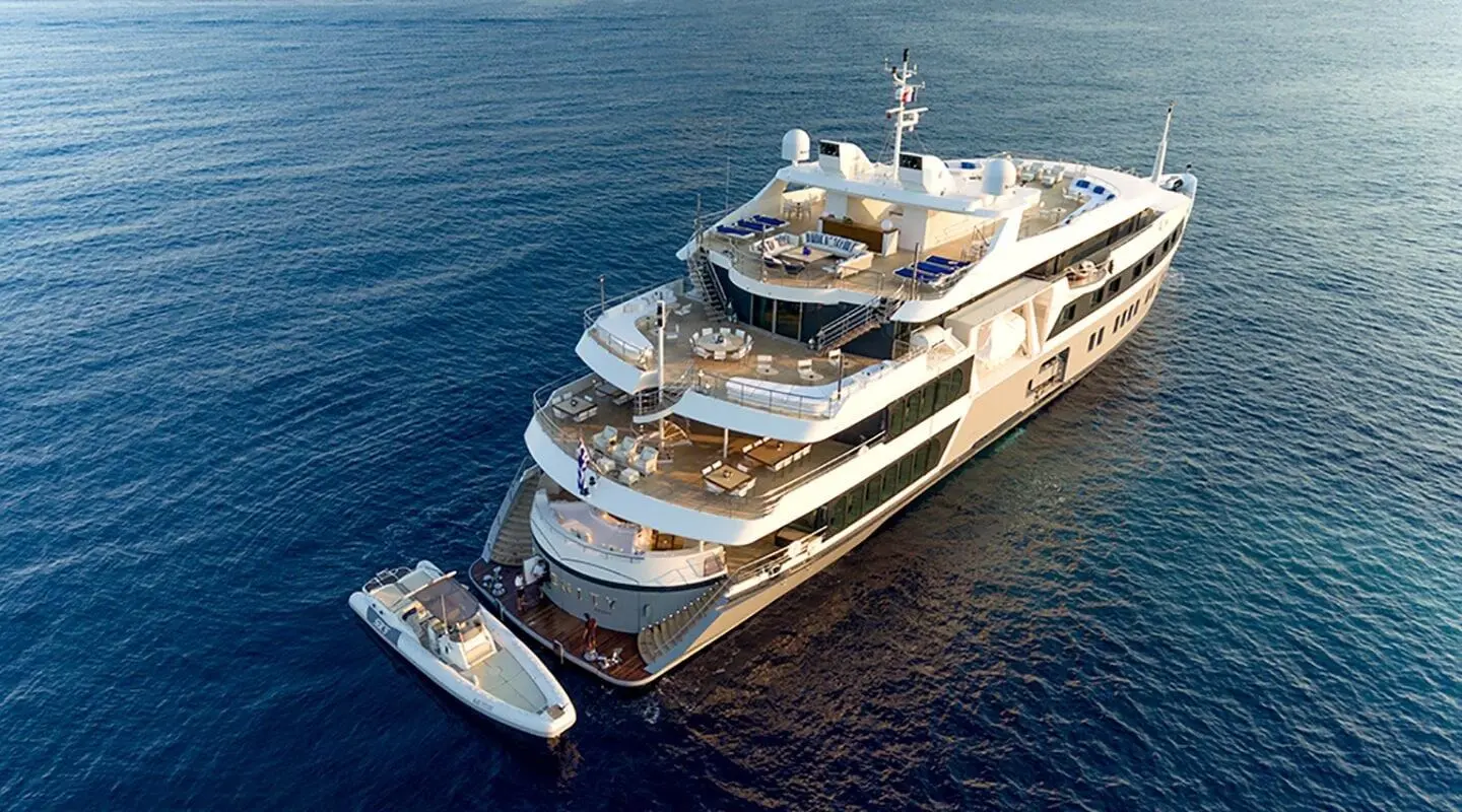 Marquise luxury yacht dockside with two smaller boats nearby at sea