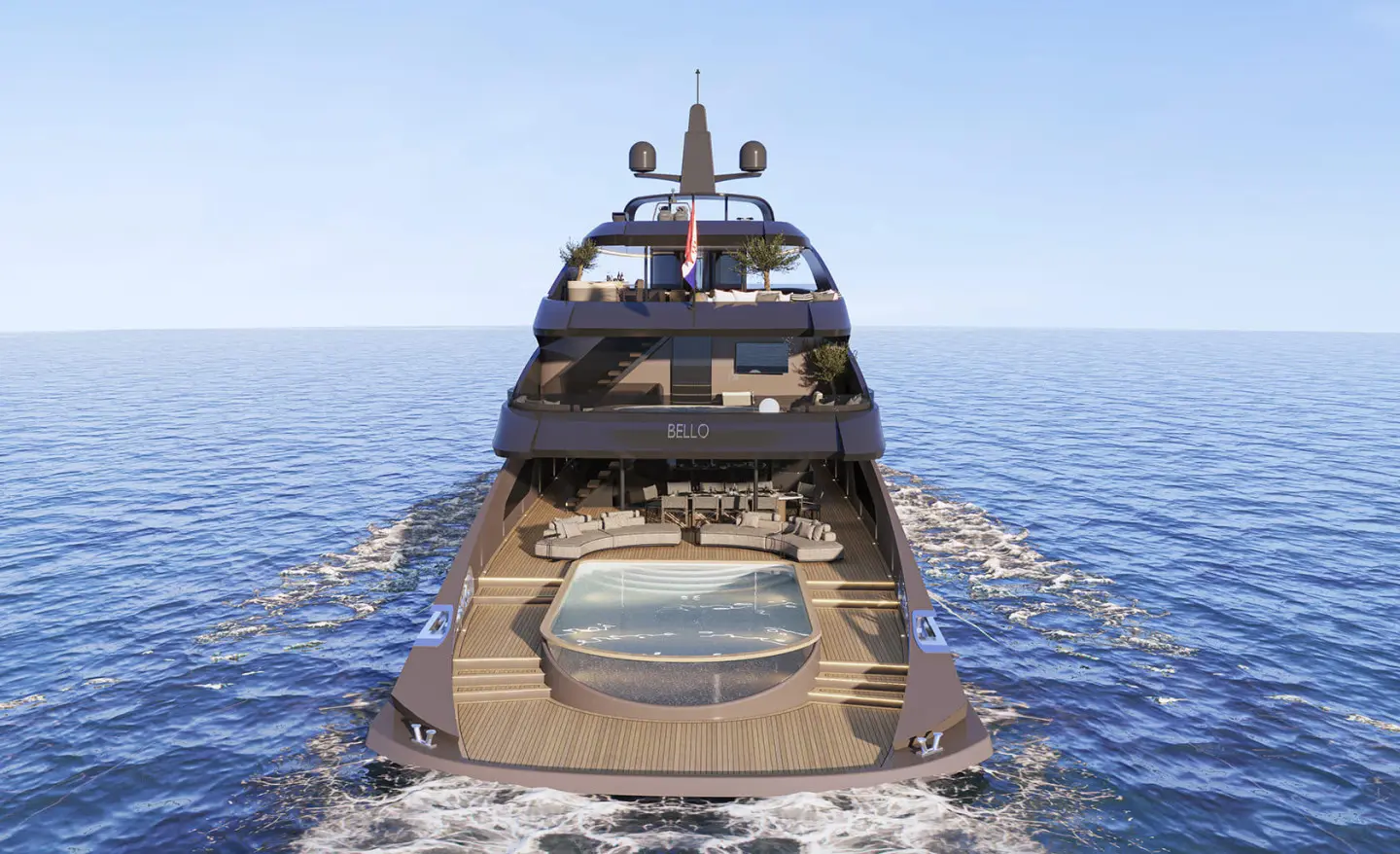 Yacht Bello sailing on calm blue sea, stern view with deck loungers