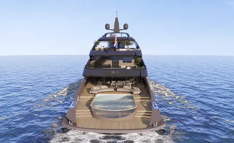 Yacht Bello sailing on calm blue sea, stern view with deck loungers
