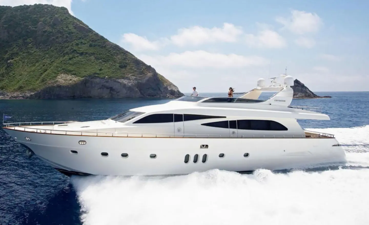 Miraval luxury motor yacht cruising near rocky coastline with blue water