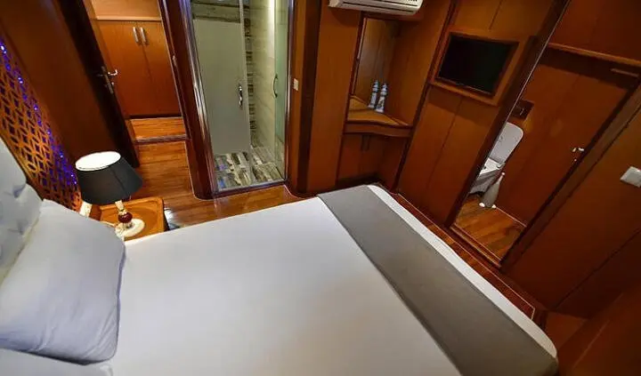 Blu Dream yacht cabin with double bed and ensuite storage and wood interior