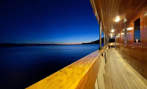 Night-lit yacht deck with wooden exterior along the railing