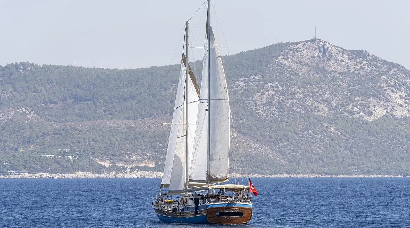 Gozdem The One gulet sailing on blue sea with sails up near distant hills