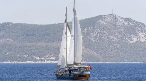 Gozdem The One gulet sailing on blue sea with sails up near distant hills