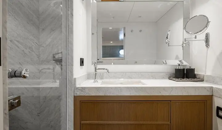 Illusion II master cabin with king bed, ensuite in view, elegant wood vanity