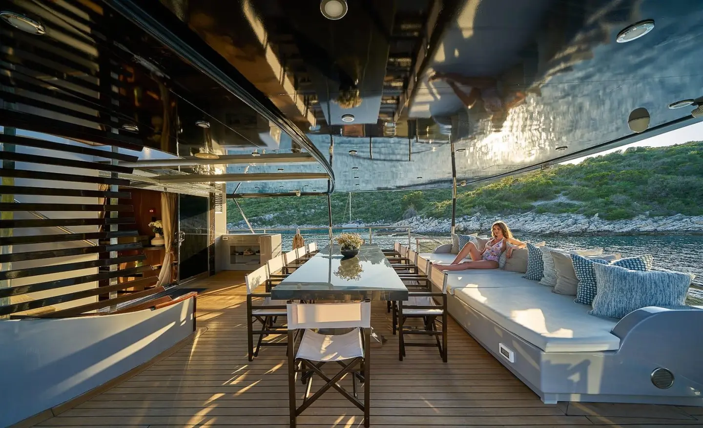 Rara Avis yacht dining on deck at sunset, table set under awning