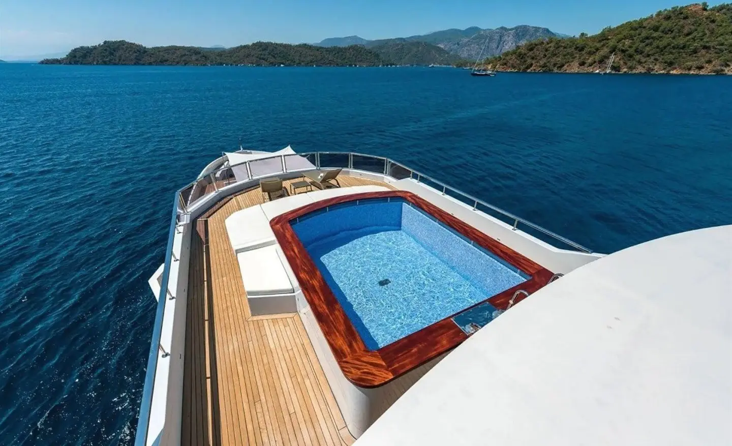 On the bow of Ocean Breeze, a wooden deck with a blue Instagram-shaped pool on the yacht