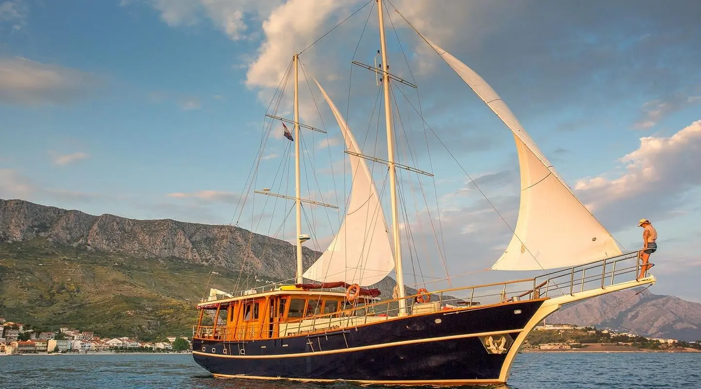 Altair luxury gulet anchored at sunset with sails and calm blue water