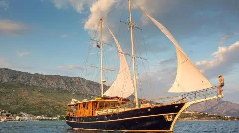 Altair luxury gulet anchored at sunset with sails and calm blue water