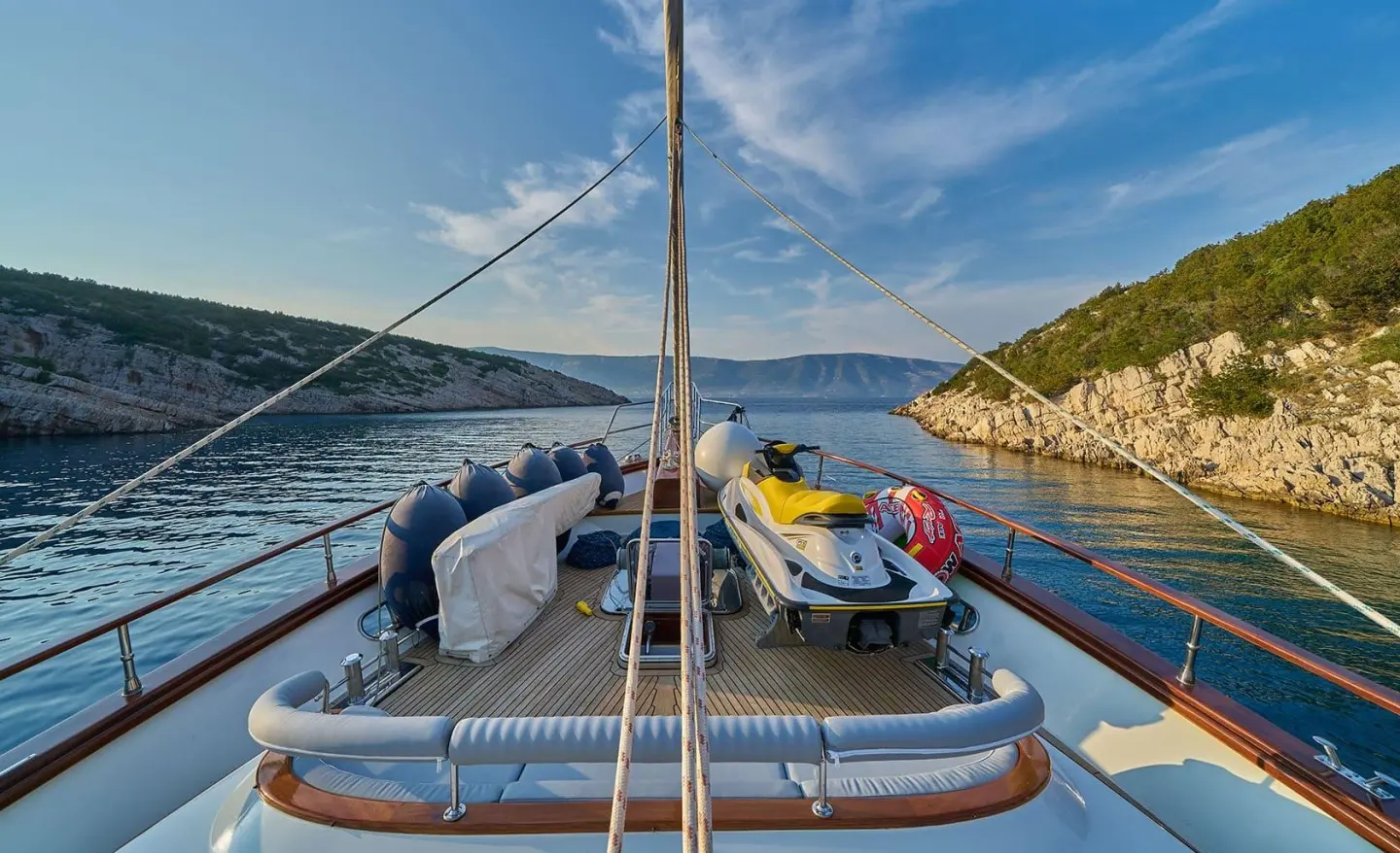 View from bow of Lotus yacht at sunset with deck seating and calm turquoise water