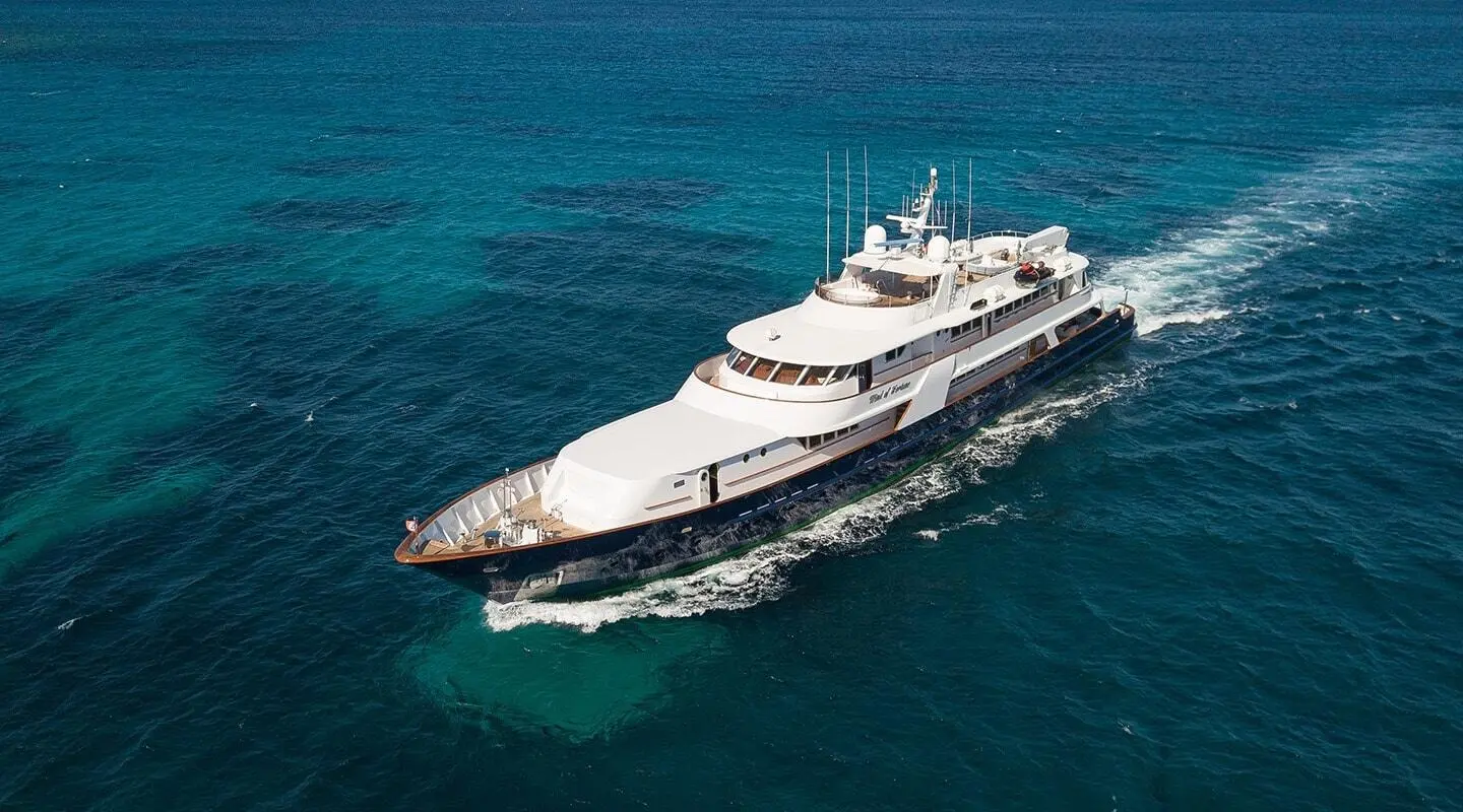 A white motor yacht named Wind Of Fortune sails on blue ocean waters