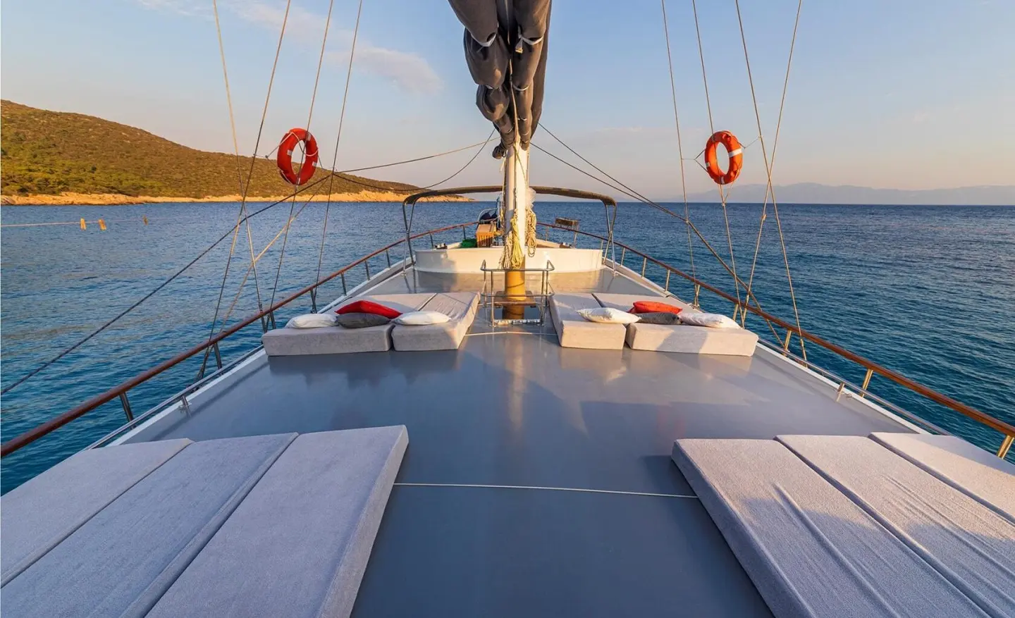 Relaxing yacht deck at sunset with seating and calm blue sea
