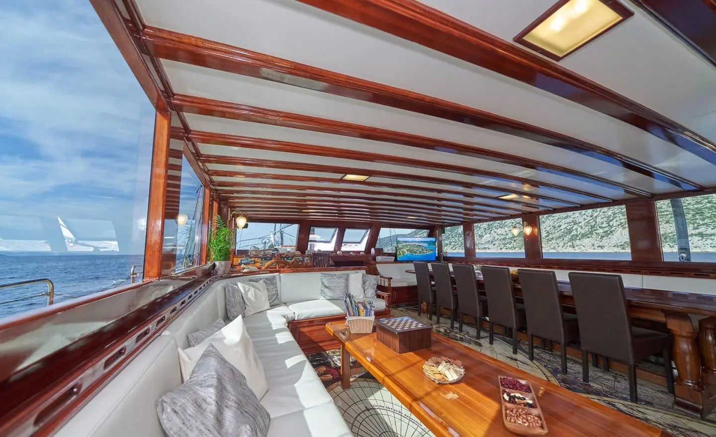 Luxurious yacht interior seating under striped awning with wooden table