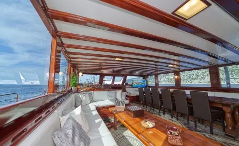 Luxurious yacht interior seating under striped awning with wooden table