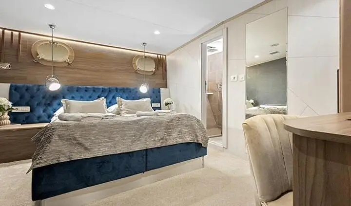 Master cabin with king bed, ensuite, beige tones, large mirror, soft lighting