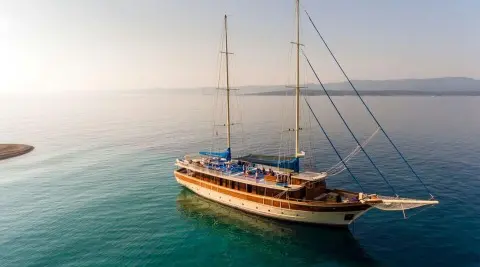 Tajna Mora luxury gulet at sunset with two masts and teal sea