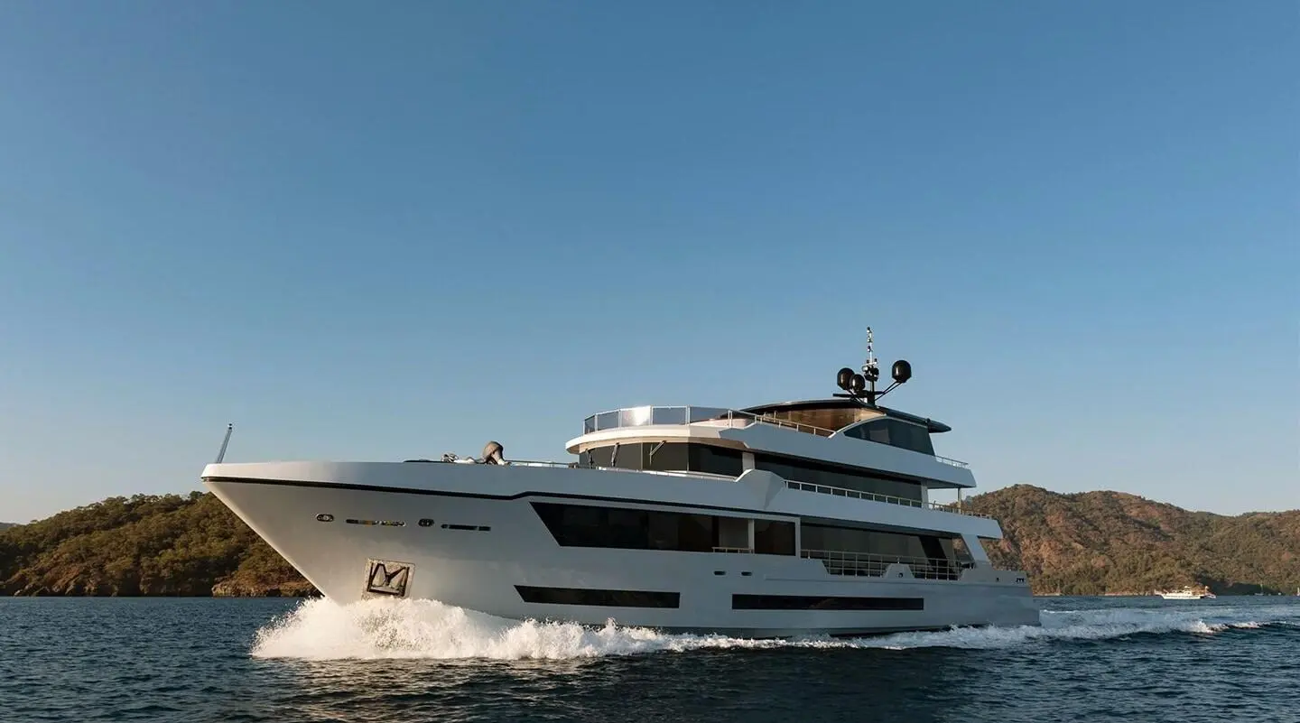 Ocean Breeze motor yacht cruising on blue water with white wake and clear sky