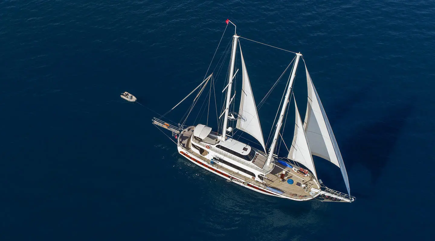 Two-masted sailing yacht on deep blue sea with open deck