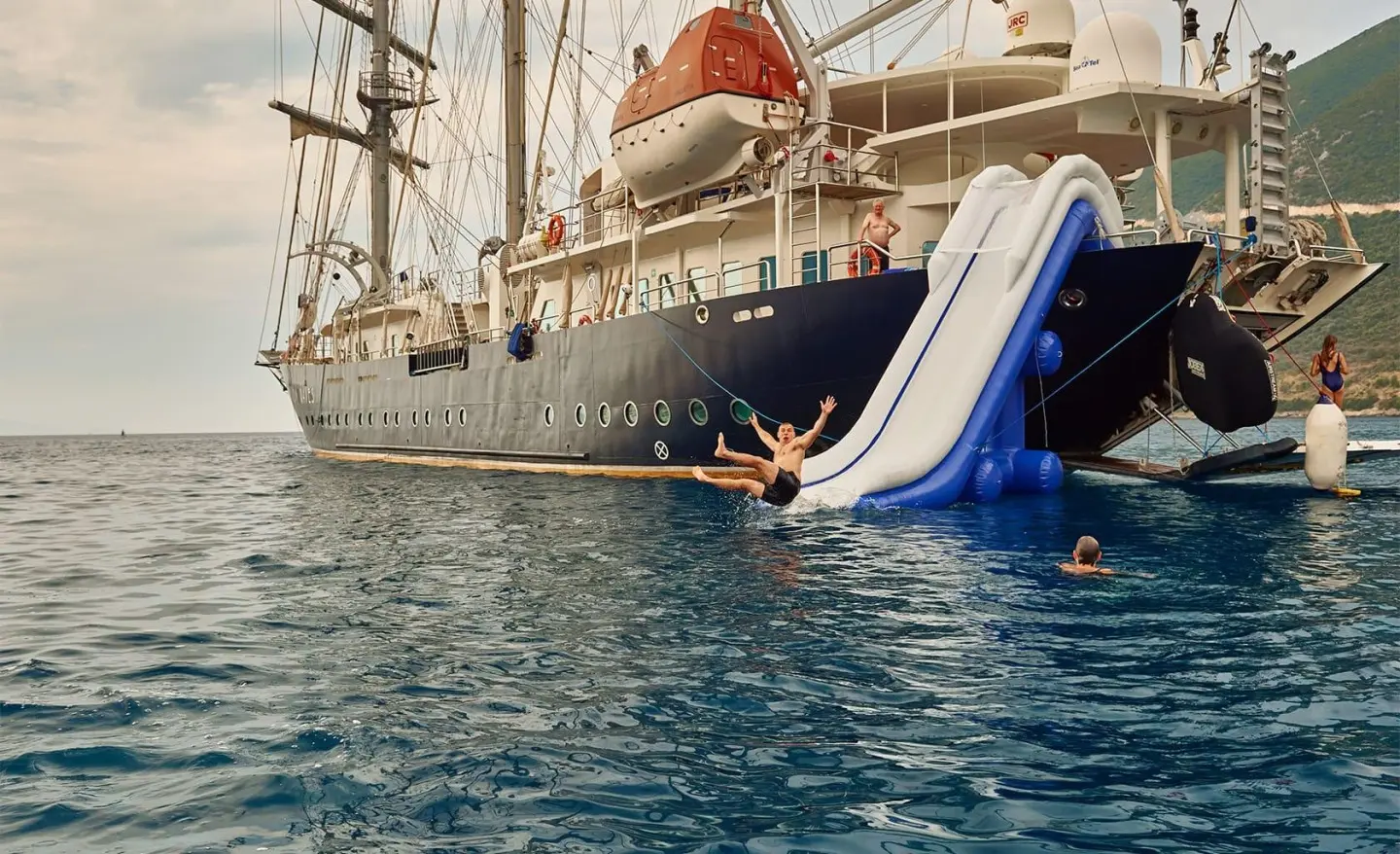 Yacht named Running on Waves moored at dock with a small inflatable slide ladder