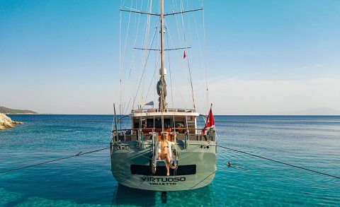 Rear view of the sailing yacht Virtuoso anchored in clear blue water