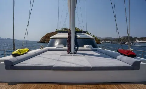 Sunlit rear deck of luxury yacht De Love, calm sea in background