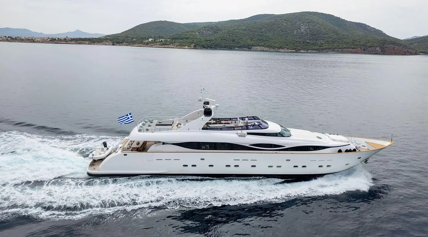 White motor yacht Pareaki II cruising on calm sea with people on aft deck