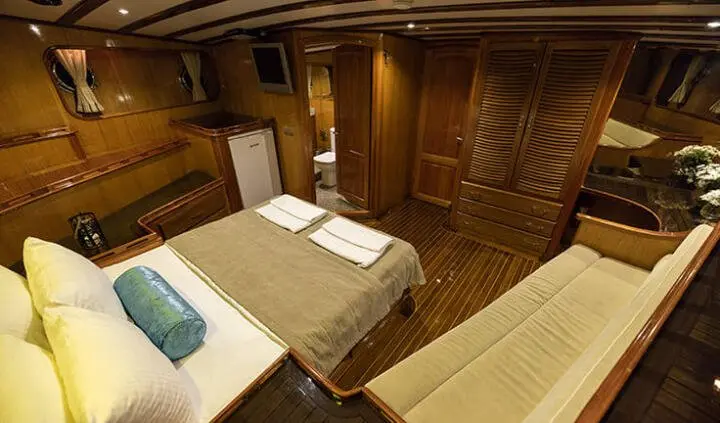 Kayhan 5 master cabin with large bed and wooden cabinetry, ensuite door visible