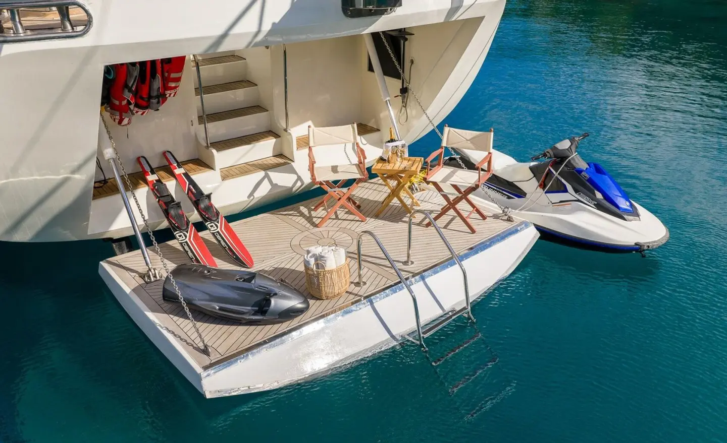 Alessandro I yacht stern deck with seating, diving gear, and a jet ski on calm blue water
