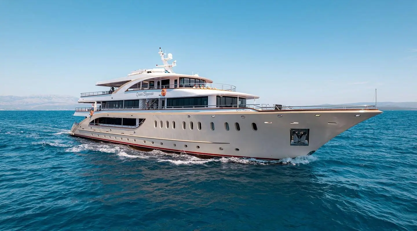Luxurious Queen Eleganza yacht cruises in clear blue waters, side view