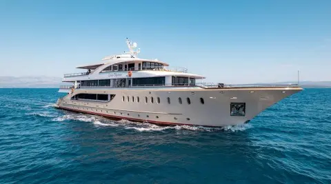 Luxurious Queen Eleganza yacht cruises in clear blue waters, side view