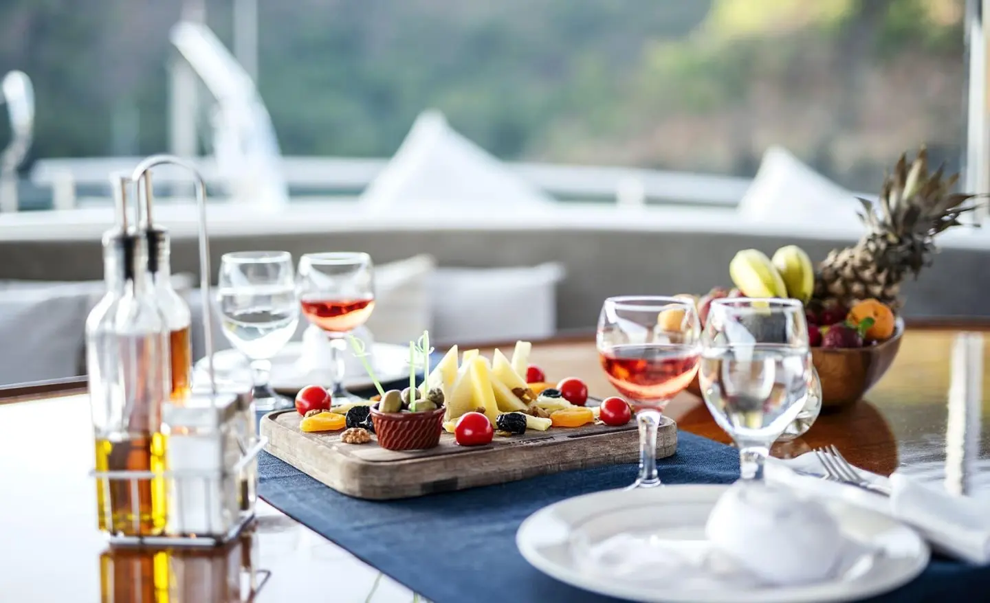 Charcuterie board with cheese, fruits and drinks on a yacht table