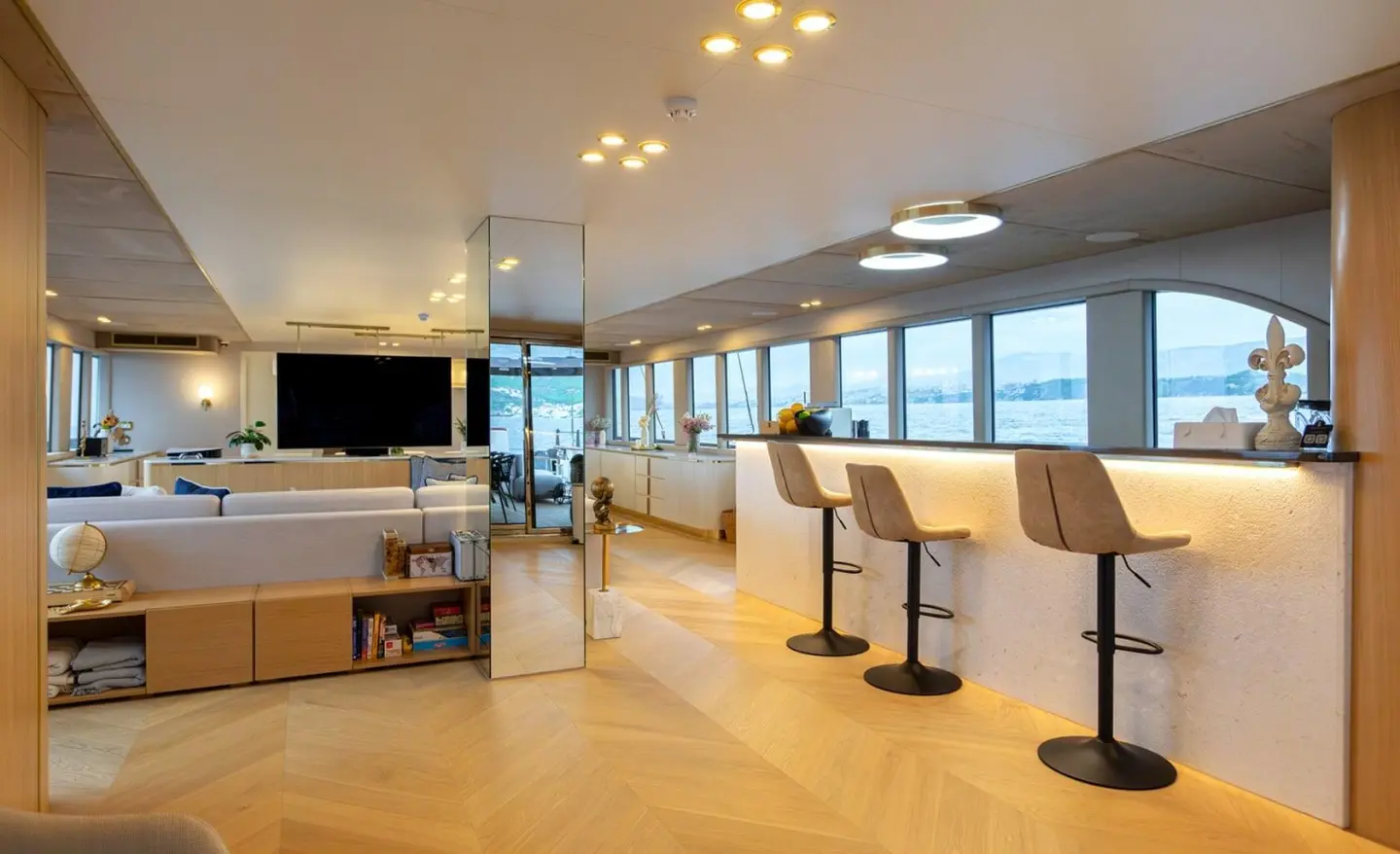 Luxurious yacht Scorpios saloon with panoramic windows and seating area at sunset