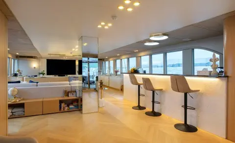 Luxurious yacht Scorpios saloon with panoramic windows and seating area at sunset