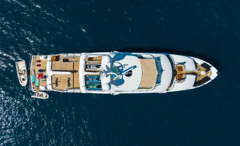 Top-down view of Serenity luxury yacht anchored in calm blue water with deck seating