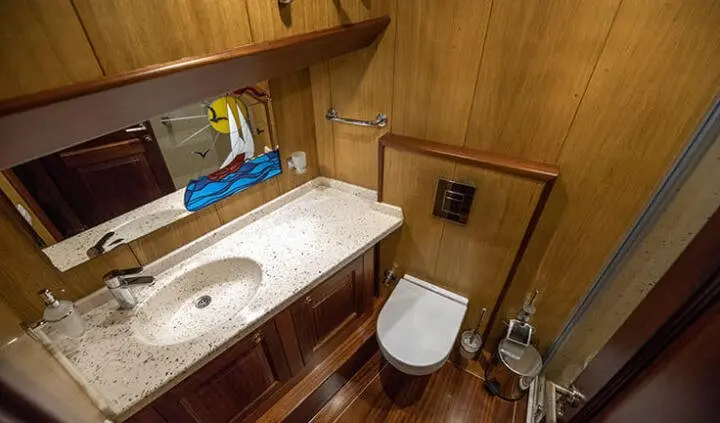 Cabin ensuite bathroom on Kayhan 3 yacht, wooden walls, sink, mirror, toilet