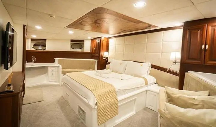 Luxurious yacht master cabin with king bed, wood accents, bright lighting