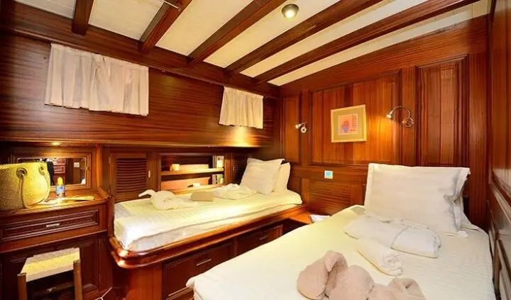 Twin cabin aboard Samarkand yacht with wood paneling and two beds