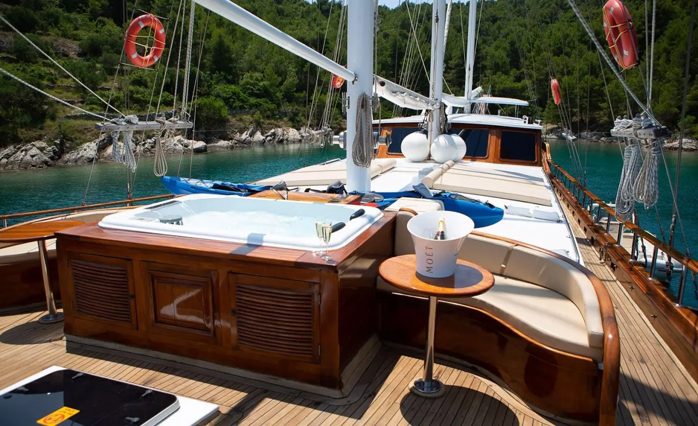 Dolce Vita yacht bow deck with wooden benches, life rings, and ropes