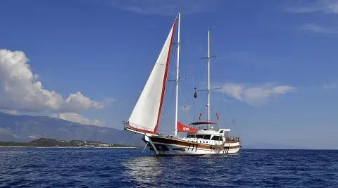 Blu Dream sailing yacht with white hull, red boat, and sails on calm blue sea