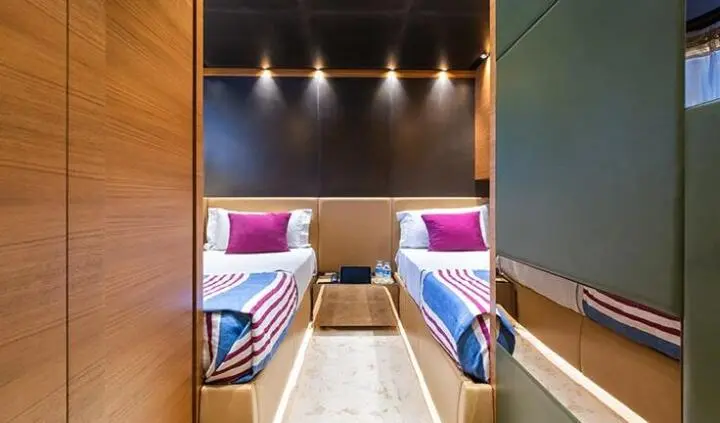Twin cabin ensuite beds aboard Takara One yacht, two single beds with purple accents