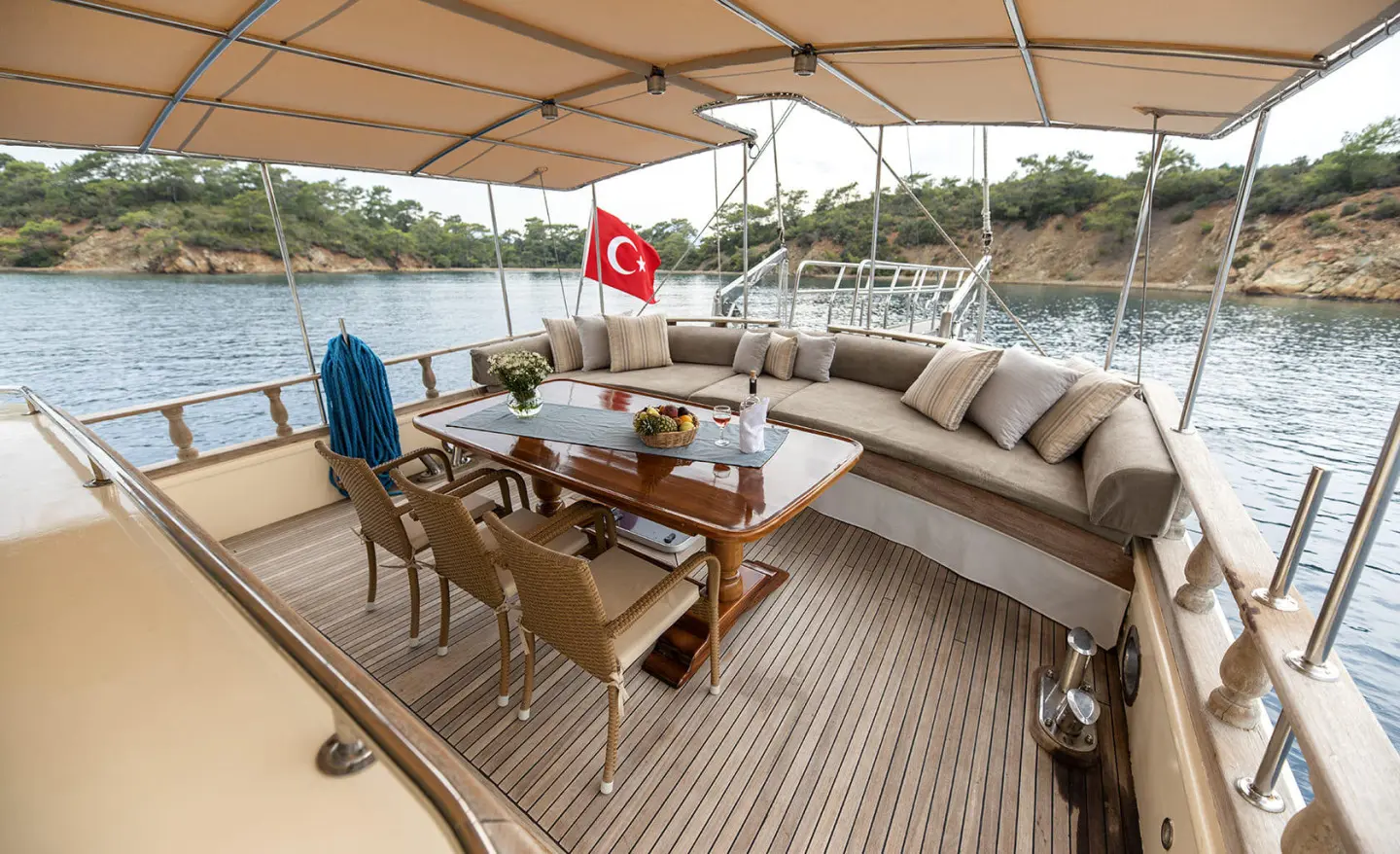 Luxury yacht Faralya outdoor deck with seating, table, and sunshade at sunset