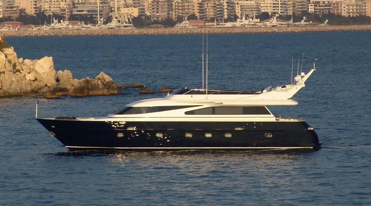 Luxury yacht Zoi gliding on calm sea with skyline in background